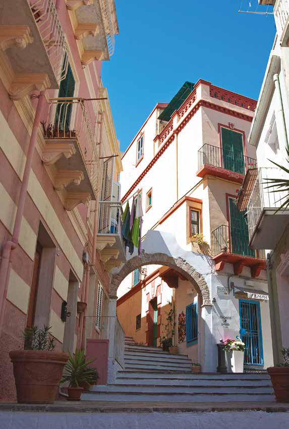 Una via di Carloforte, tra facciate colorate e archi